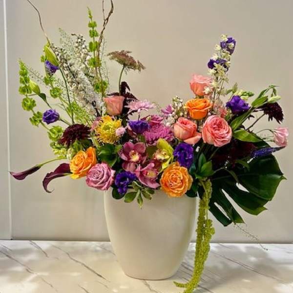 Colorful mixed flower arrangement in a white vase