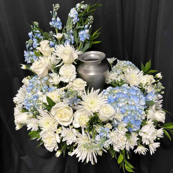 White and blue floral arrangement around a silver urn