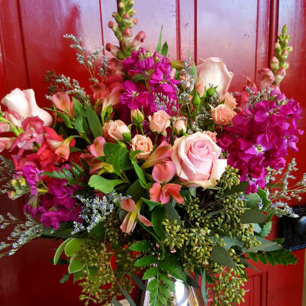 Mixed pink and peach flower arrangement in a metallic vase