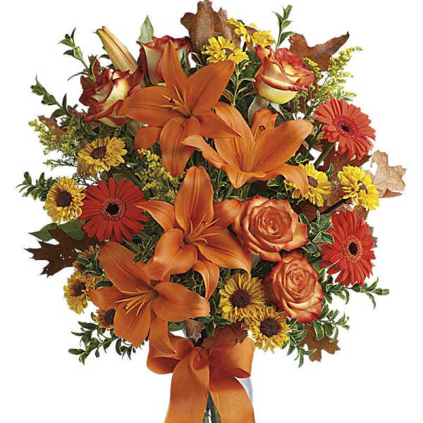 Orange lilies and roses with yellow daisies in a glass vase