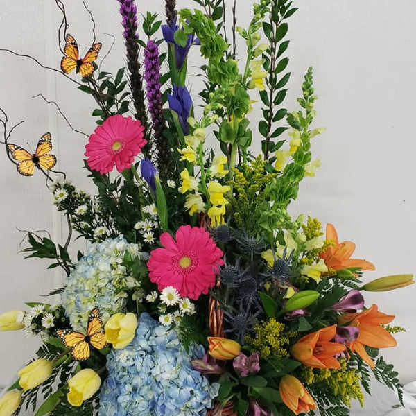 Tall mixed flower basket with butterflies and bright blooms