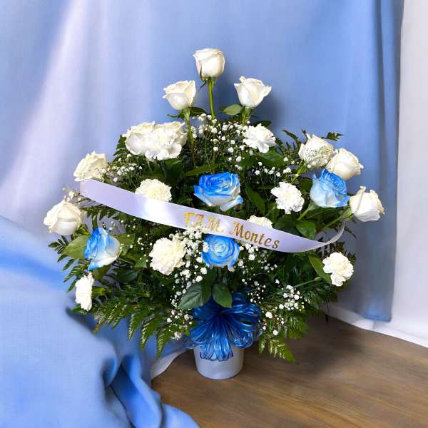 White and blue roses arranged in a vase with a ribbon