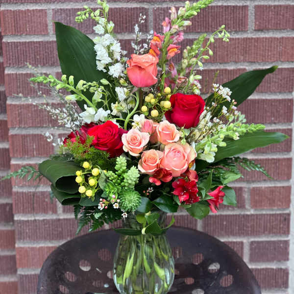 Mixed bouquet of roses and snapdragons in a glass vase