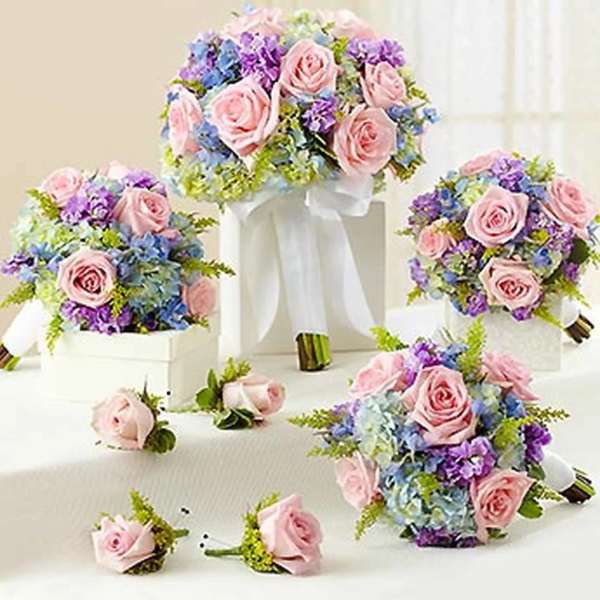 Pink rose bouquets with blue and purple flowers on white stands