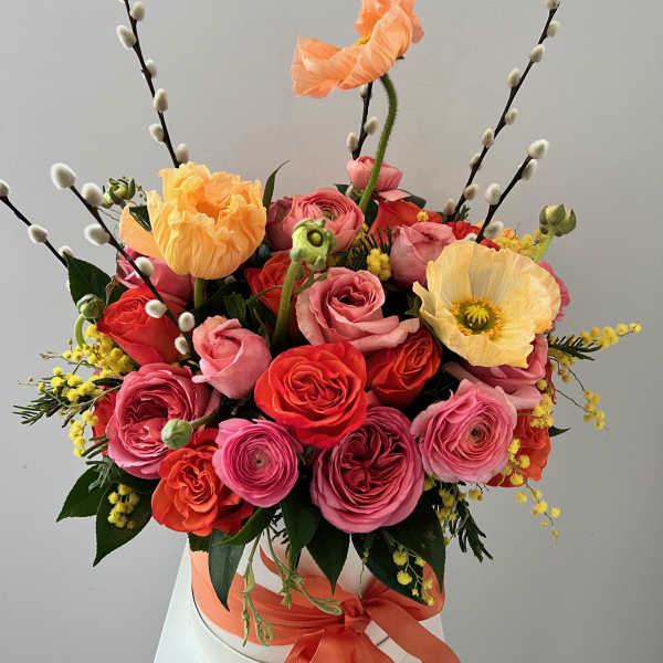 Bouquet of pink and orange roses with poppies in a white hat box