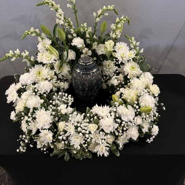 White floral wreath around a decorative urn