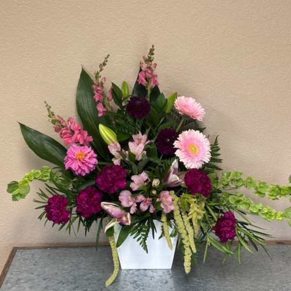 Pink and purple floral arrangement in a white vase