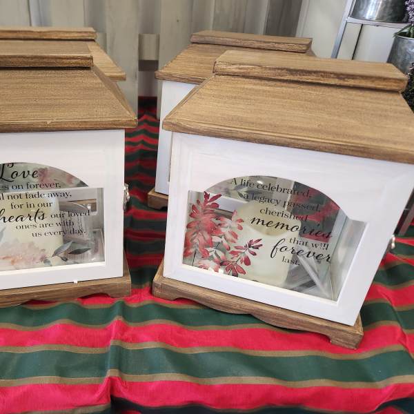 Decorative memorial lanterns with framed floral inserts and printed quotes