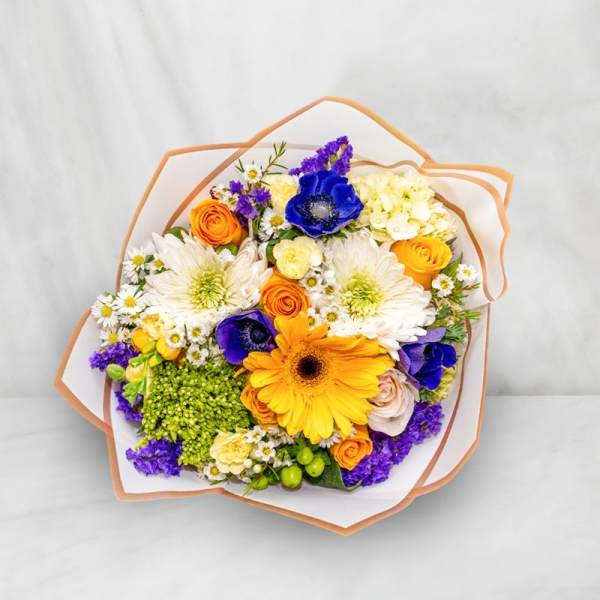 Mixed bouquet with orange, yellow, white, and purple flowers wrapped in paper