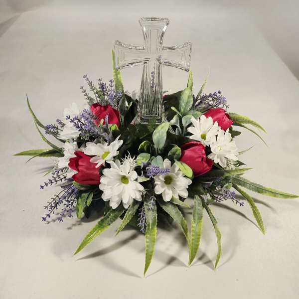 Floral arrangement with a clear glass cross centerpiece
