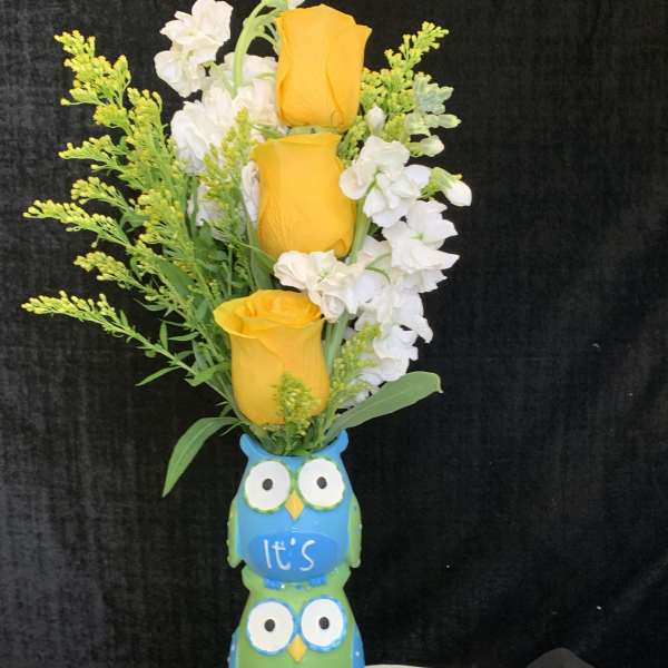 Yellow roses and white flowers in a blue owl vase