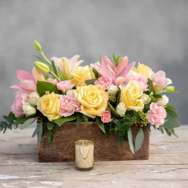 Pastel bouquet of roses, lilies, and carnations in a wooden box