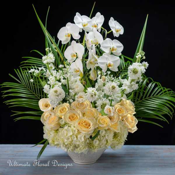 White orchids and cream roses in a low white vase