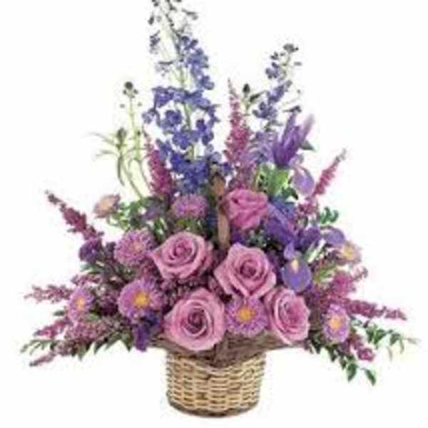 Basket arrangement of pink roses and purple flowers