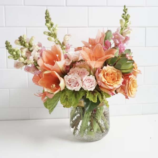 Peach and pink floral arrangement in a clear glass vase