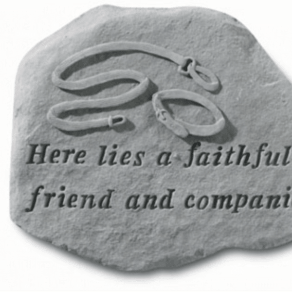 Gray memorial stone with engraved text and a carved dog collar