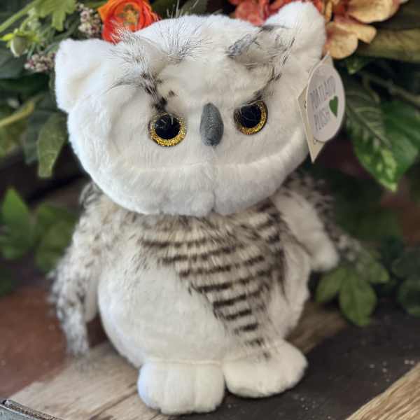 Plush owl in front of a floral arrangement
