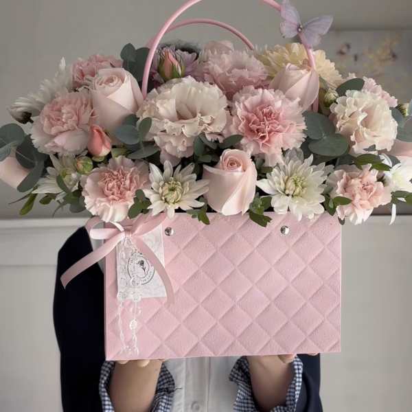 Pink flower box arrangement with roses, carnations, and daisies