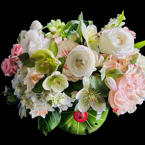 Pastel bouquet of white and pink flowers in a green vase