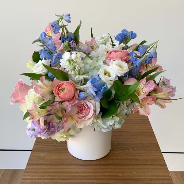 Pastel bouquet of mixed flowers in a white vase
