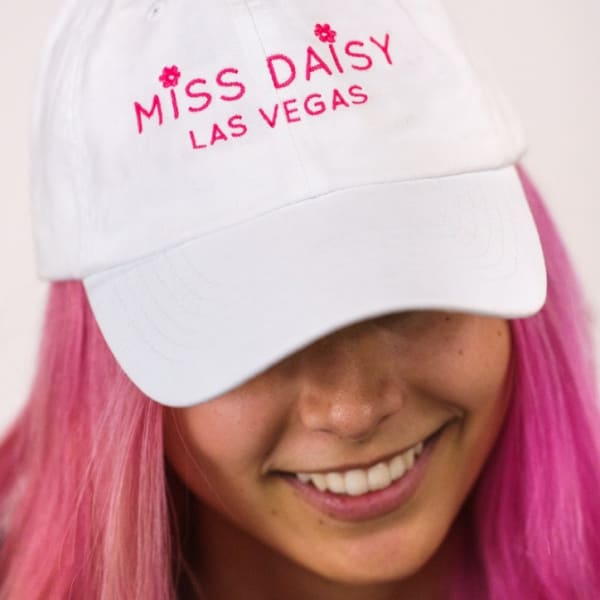 White cap with pink "Miss Daisy Las Vegas" embroidery