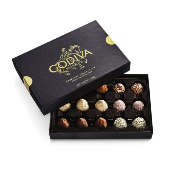 Open black Godiva truffle box showing assorted round chocolates in rows