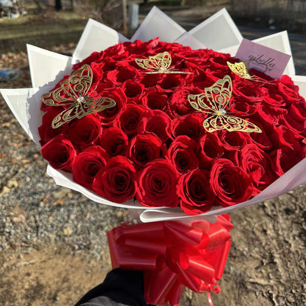 Large bouquet of red roses with gold butterfly accents and a red ribbon