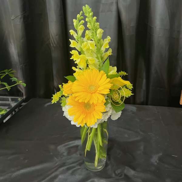 Yellow gerberas and snapdragons in a clear glass vase