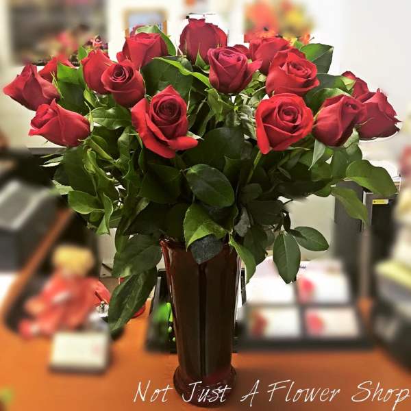 Red roses arranged in a tall vase
