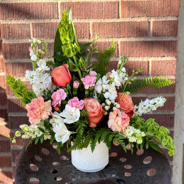 Pink and white floral arrangement in a white vase
