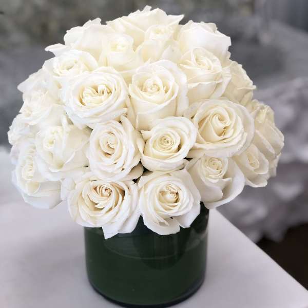 White rose bouquet in a dark green vase