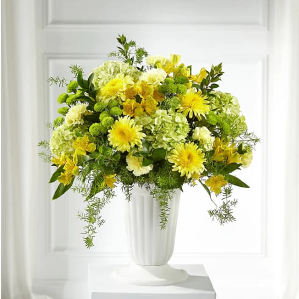 Yellow and white floral arrangement in a white vase