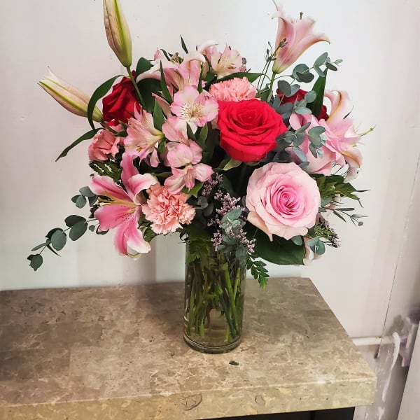 Pink and red mixed bouquet in a clear glass vase