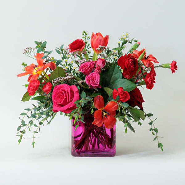 Bright mixed bouquet in a pink glass vase