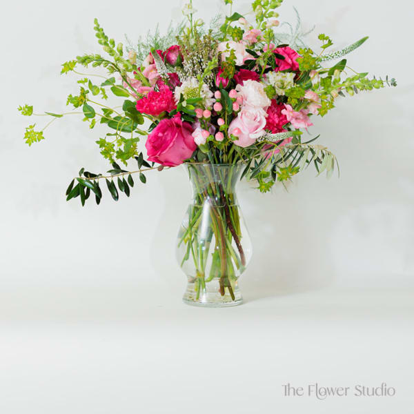 Pink and white mixed flower arrangement in a clear glass vase