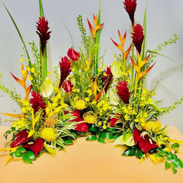 Tropical floral arrangement with red, yellow, and orange blooms