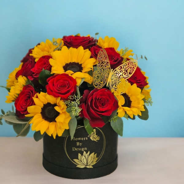 Red roses and yellow sunflowers in a black hat box