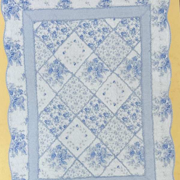 Blue and white quilted pillow with floral patchwork pattern
