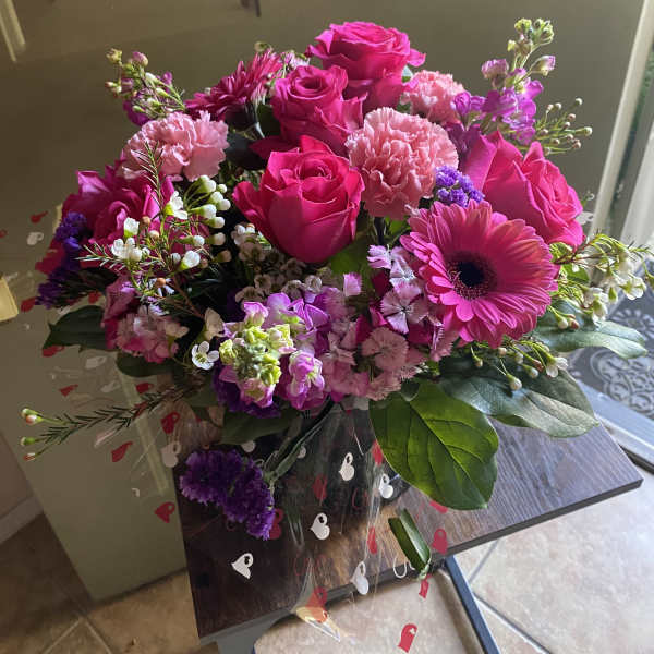 Pink roses and mixed blooms in a clear wrap