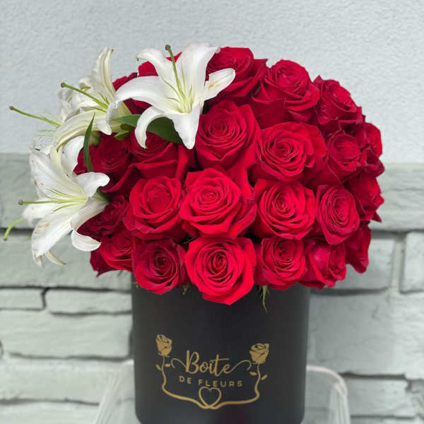 Red roses with white lilies in a black hat box