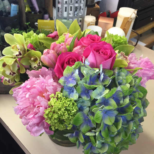 Bouquet of pink roses, hydrangeas, and green orchids in a vase