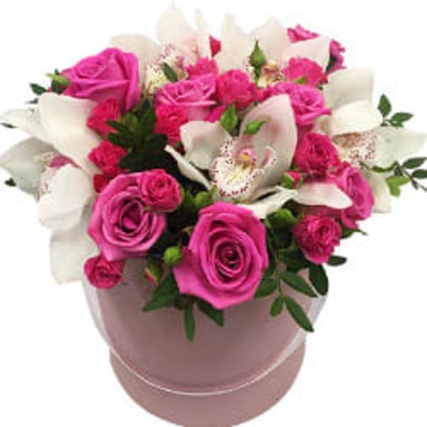 Pink roses and white orchids arranged in a round pink box