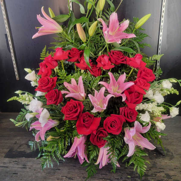Large arrangement of red roses, pink lilies, and white flowers