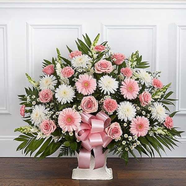 Fan-shaped pink and white arrangement with roses and daisies in a white container with a pink bow