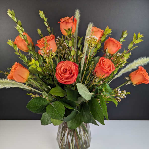 Orange roses arranged in a clear glass vase