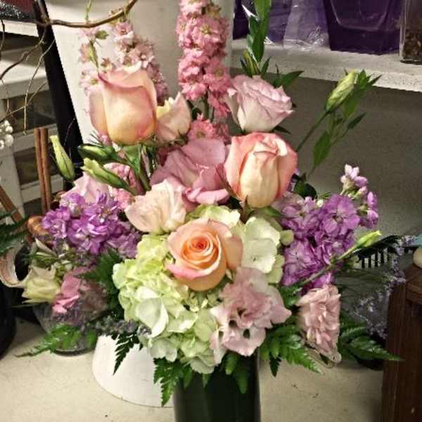 Pink and lavender floral arrangement in a green vase
