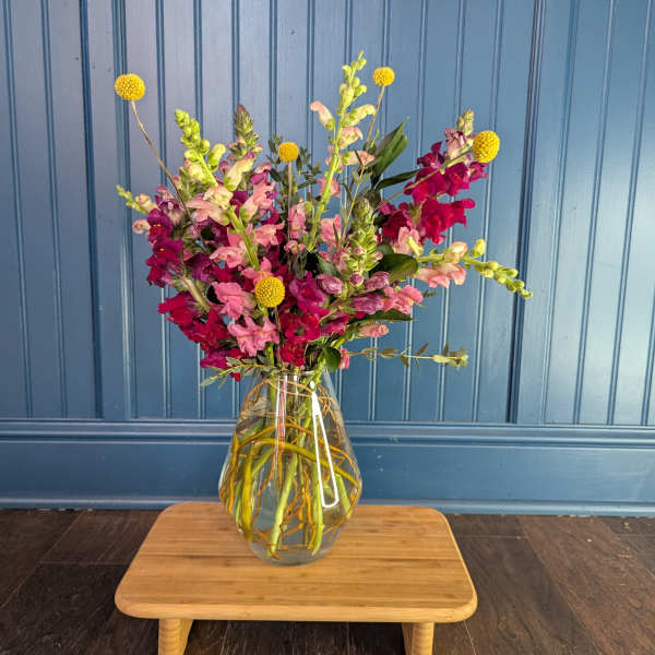 Mixed pink and magenta flowers in a clear glass vase