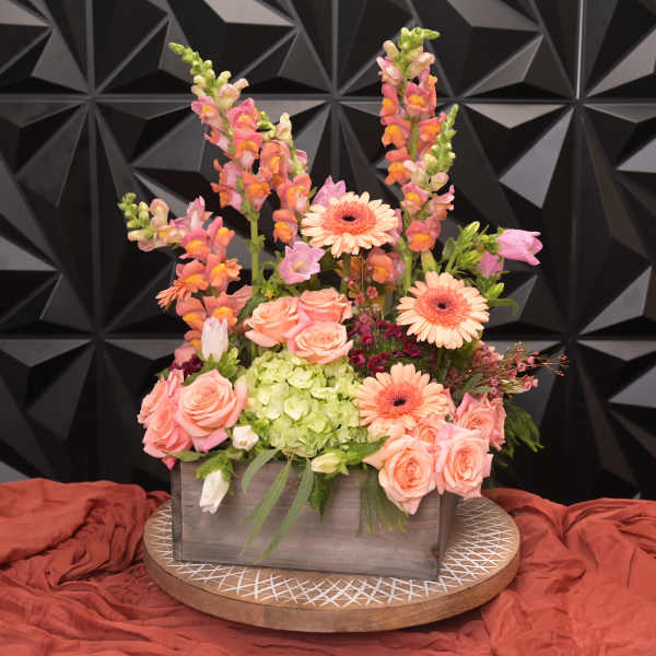 Peach roses and gerbera daisies in a wooden box with snapdragons