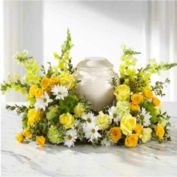 Yellow and white floral wreath around a silver urn