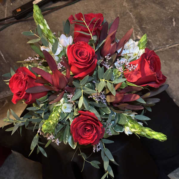 Bouquet of red roses with white accent flowers and greenery